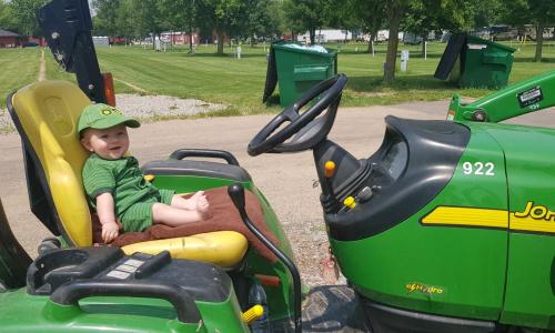 Youngest camper, Jesse Jeffrey, hard at work on John Deer Tractor