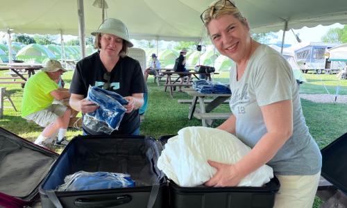 Mireille and Erna sorting out shirts and caps
